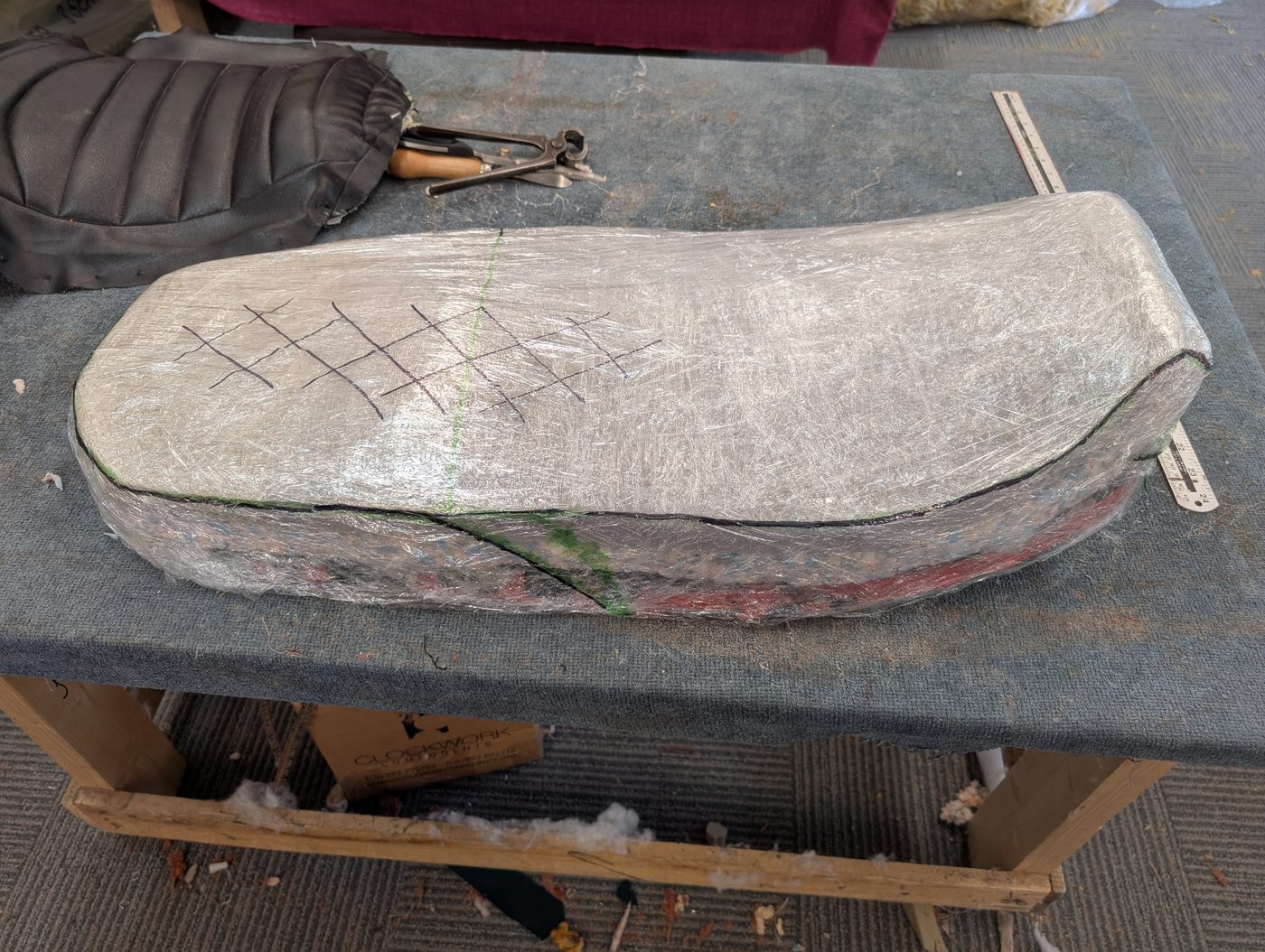 The reshaped seat wrapped tight in shrink wrap, with the seam lines and balance marks drawn on.