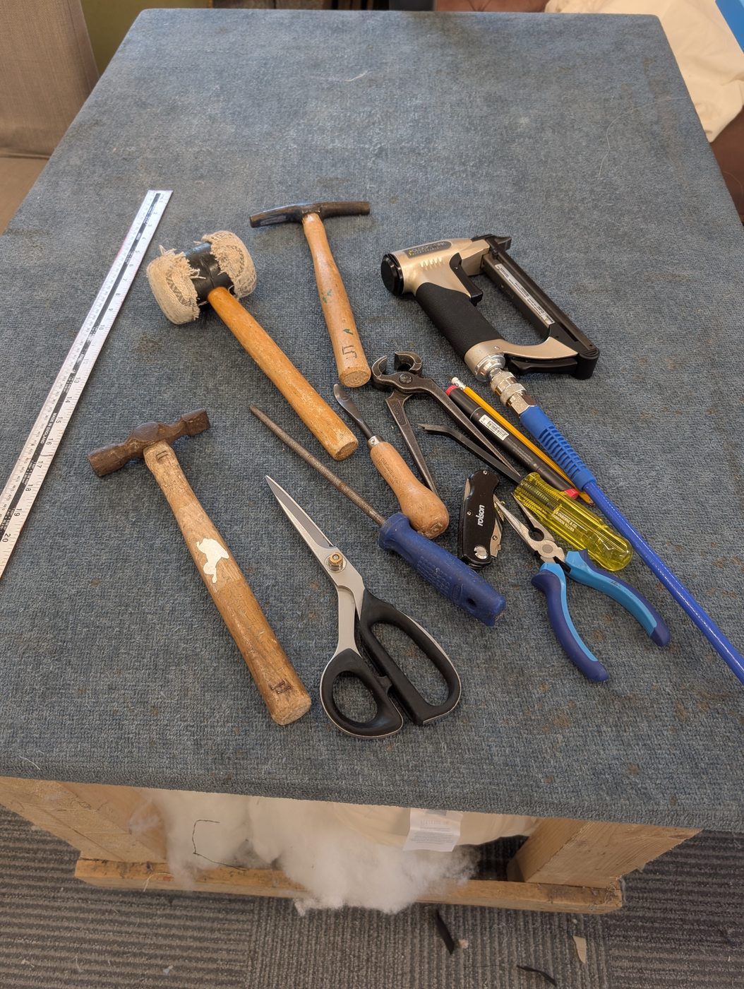 The tool kit laid out — hammers, mallet, staple unpicker, regulator, shears, ripping tools and the staple gun.