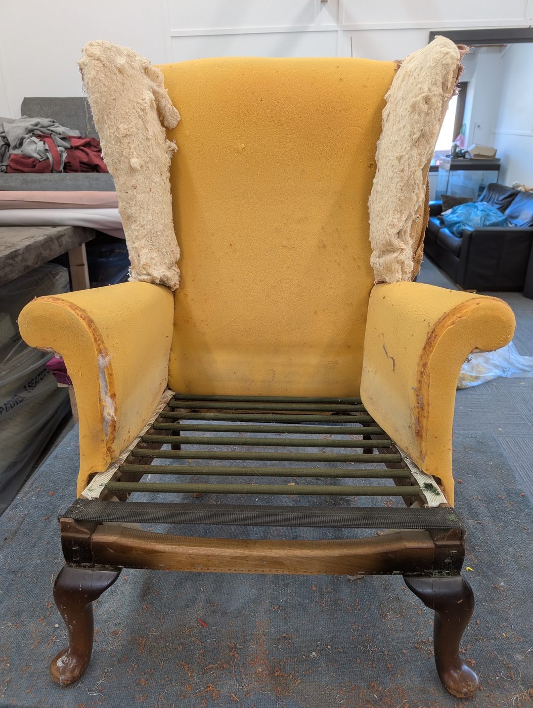 Stripped back — the hardwood frame, the original sprung seat and the foam all checked for reuse.