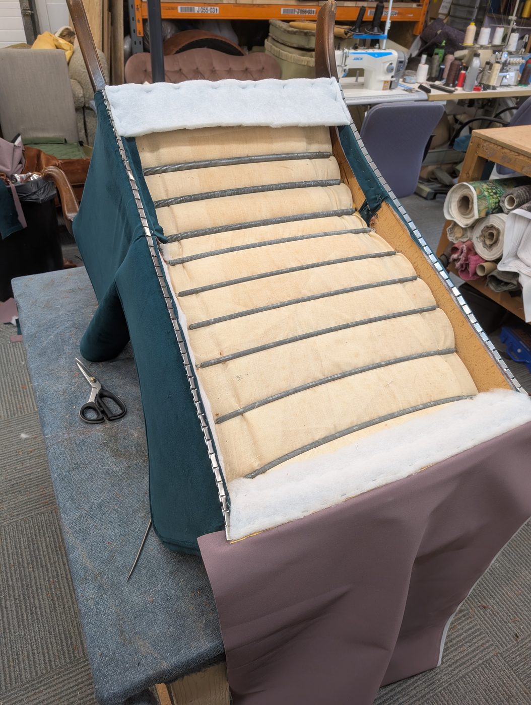 The outside arms and back going on, back-tacked with a metal tacking strip for a straight edge.
